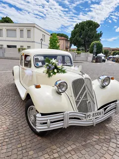 L'auto d'epoca con fiori bianchi e azzurri, su una piazza di porfido